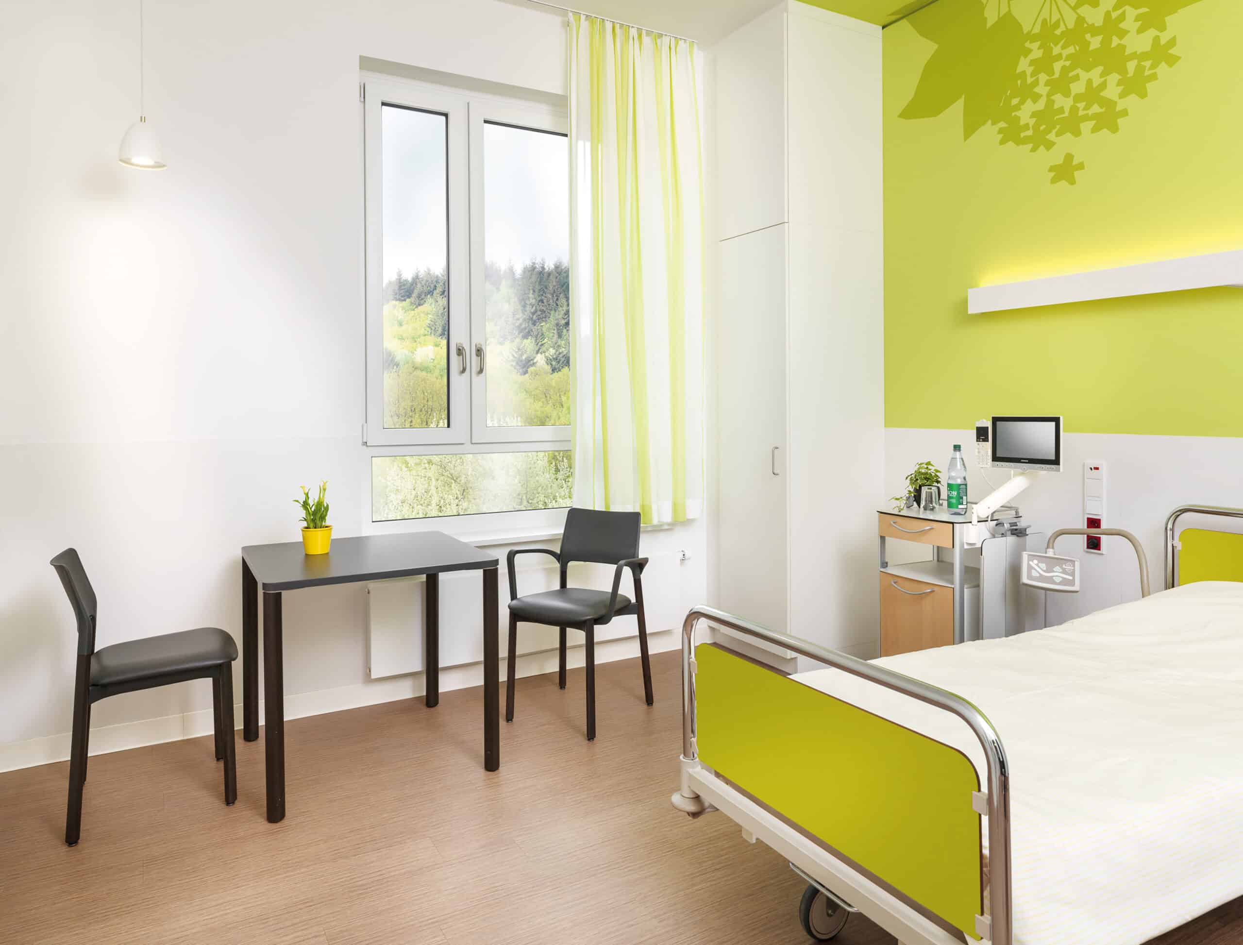 Modernes Patientenzimmer mit Bett und Tisch