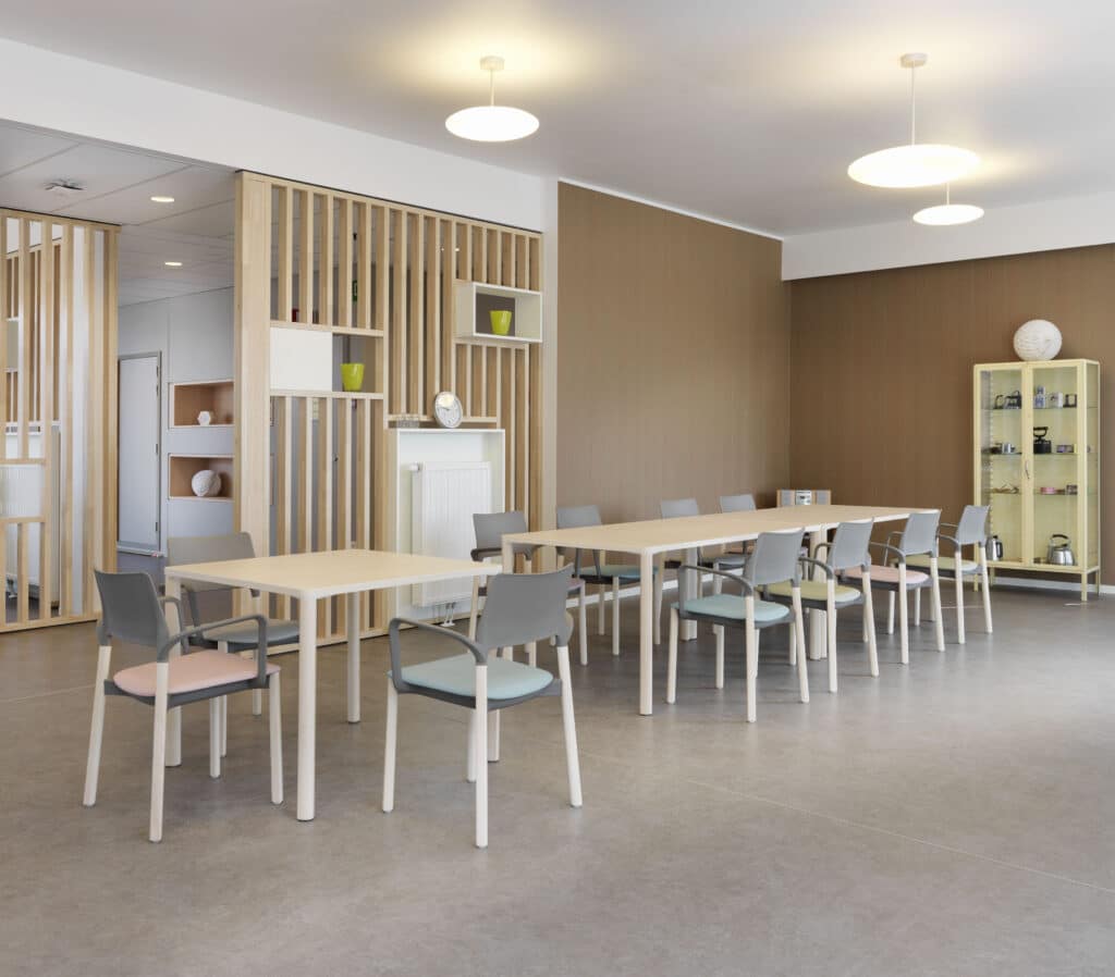 Moderner Konferenzraum mit Tischen und Stühlen.