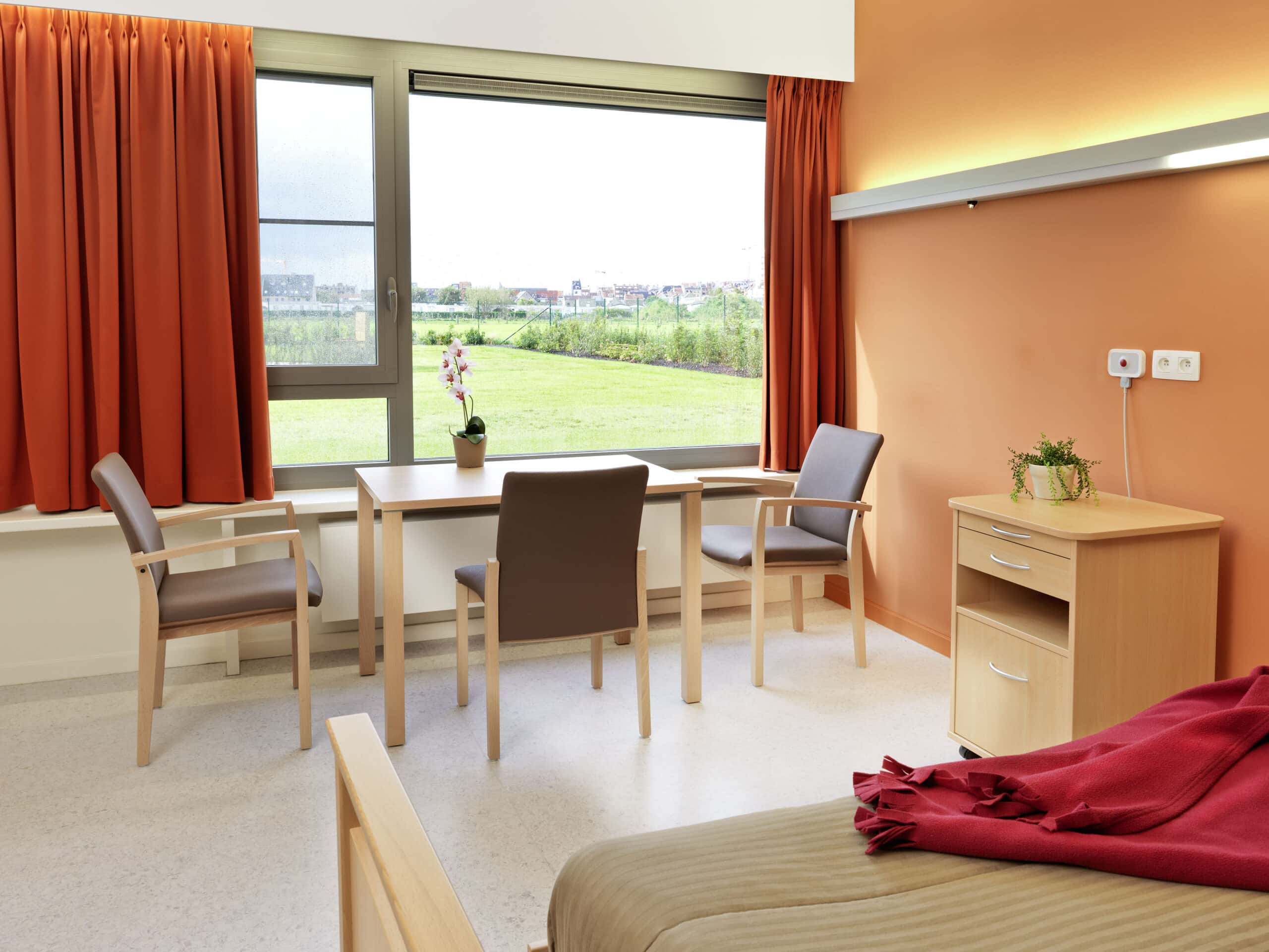 Helles Zimmer mit Tisch, Stühlen und großer Fensteransicht